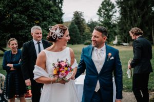 Brautpaar feiert Hochzeit auf Gut Nettehammer und schaut sich beim Auszug in die Augen